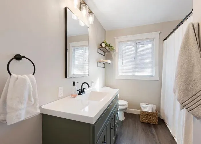 Modern bathroom featuring a floating vanity with double sinks, showcasing wood, metal, glass, and porcelain materials in a sleek design.