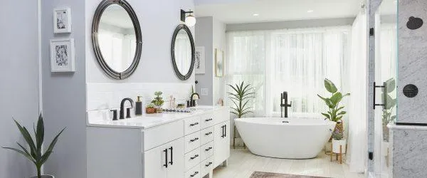 A modern bathroom with marble countertops, ceramic tile floors, and a sleek floating vanity featuring a neutral color scheme of white, cream, and gray.