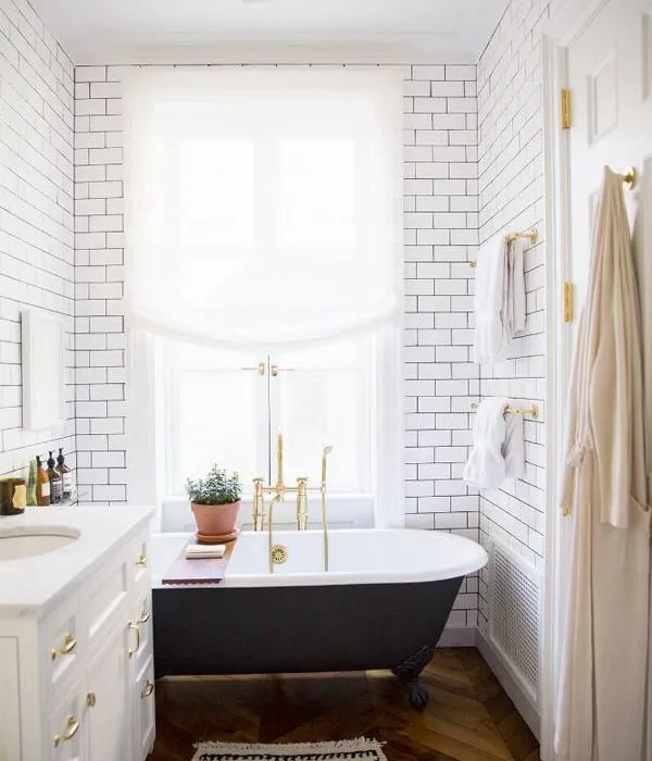 A modern bathroom featuring a black and white color scheme with tiled walls and floors, a tub, a sink, towel racks, and other elegant bathroom accessories, perfect for a stylish renovation.