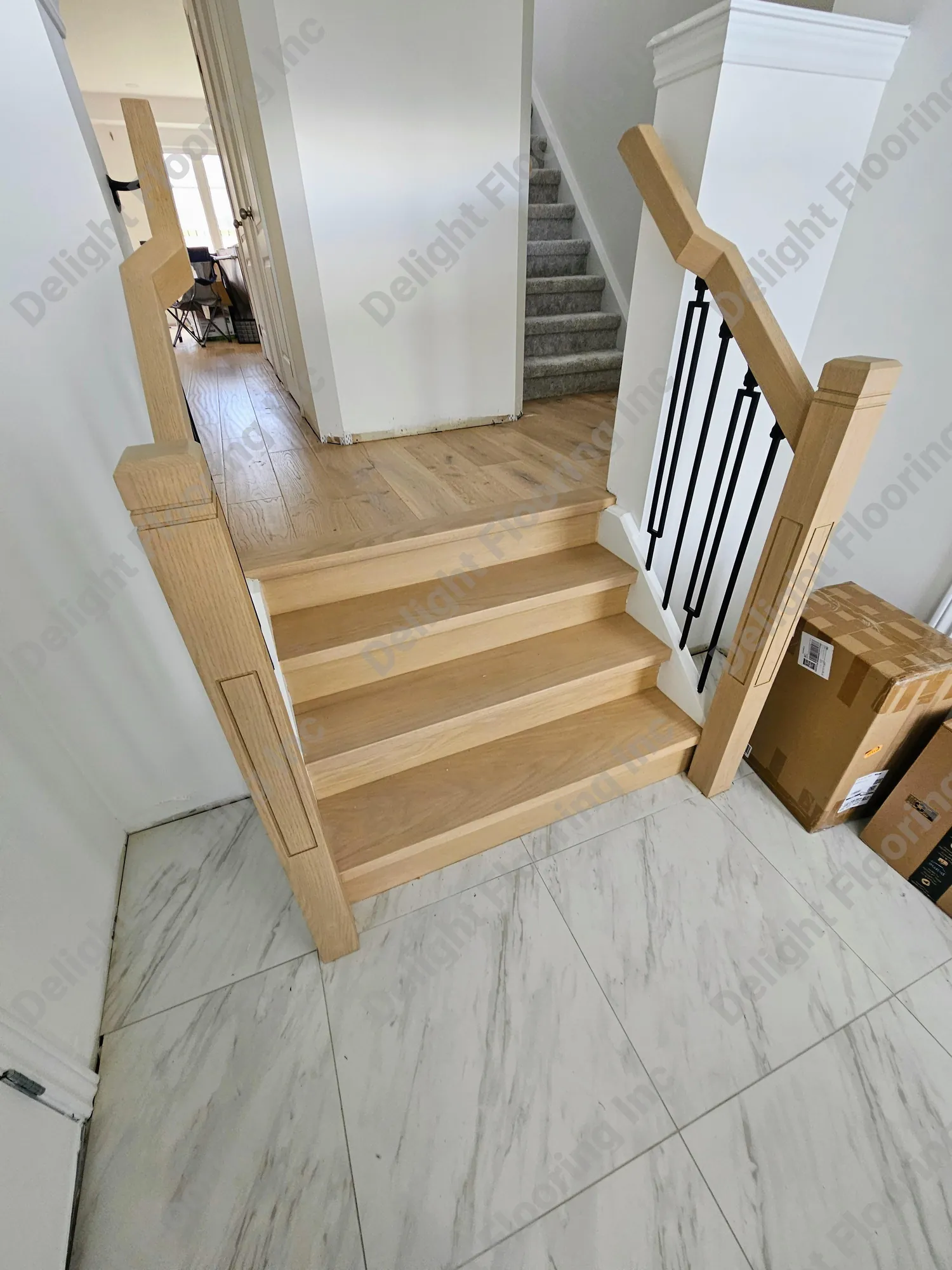 Wooden staircase with hardwood treads and risers, black railing and white spindles.