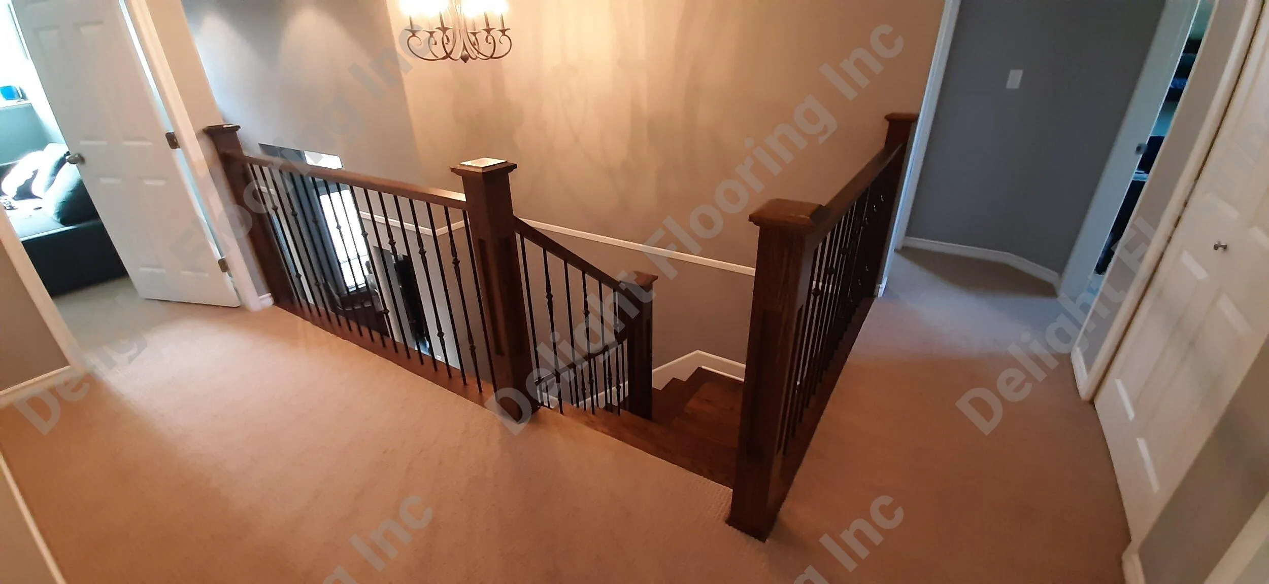 Dark wood staircase with curved railing and runner.
